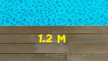 Deck of swimming pool edge 1.2 meter deep sign. photo