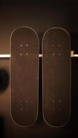 Two black skate board hanging at the black painted wall. photo