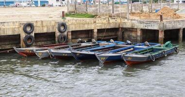 Six small wooden fishing boat docking at the pier. photo