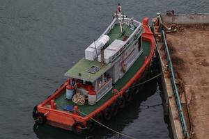 Docking Tugboat or marine vessel that maneuvers vessels by pushing or towing them. photo