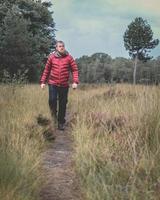 tipo con una chaqueta roja caminando por el bosque. elspeet, países bajos, 28 de septiembre de 2022 foto