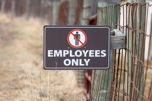 Employees only sign on the farm fence . photo