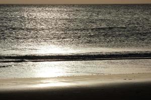 Sun setting over the sea, sunset in autumn on the beach of Zahara de los atunes, Cadiz, Andalucia, Spain photo