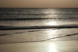 Sun setting over the sea, sunset in autumn on the beach of Zahara de los atunes, Cadiz, Andalucia, Spain photo