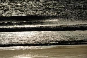 lonely, uncrowded beach with calm sea and small waves photo