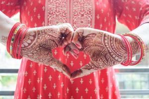 hermosa mujer vestida como tradición india con diseño de henna mehndi en ambas manos para celebrar el gran festival de karwa chauth, celebraciones de karwa chauth de una mujer india para su marido foto