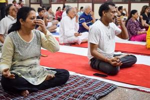 New Delhi, India, June 19 2022 -Group Yoga exercise session for people of different age groups in Balaji Temple, Vivek Vihar, International Yoga Day, Big group of adults attending yoga class in temple photo