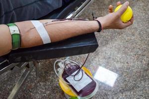 donante de sangre en el campamento de donación de sangre sostenido con una pelota hinchable en la mano en el templo balaji, vivek vihar, delhi, india, imagen para el día mundial del donante de sangre el 14 de junio de cada año, campamento de donación de sangre foto