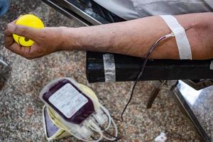 donante de sangre en el campamento de donación de sangre sostenido con una pelota hinchable en la mano en el templo balaji, vivek vihar, delhi, india, imagen para el día mundial del donante de sangre el 14 de junio de cada año, campamento de donación de sangre foto