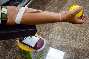 Blood donor at Blood donation camp held with a bouncy ball holding in hand at Balaji Temple, Vivek Vihar, Delhi, India, Image for World blood donor day on June 14 every year, Blood Donation Camp photo