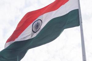 India flag flying high at Connaught Place with pride in blue sky, India flag fluttering, Indian Flag on Independence Day and Republic Day of India, tilt up shot, Waving Indian flag, Har Ghar Tiranga photo