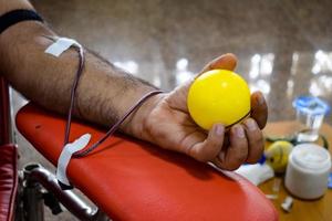 donante de sangre en el campamento de donación de sangre sostenido con una pelota hinchable en la mano en el templo balaji, vivek vihar, delhi, india, imagen para el día mundial del donante de sangre el 14 de junio de cada año, campamento de donación de sangre foto