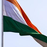 India flag flying high at Connaught Place with pride in blue sky, India flag fluttering, Indian Flag on Independence Day and Republic Day of India, tilt up shot, Waving Indian flag, Har Ghar Tiranga photo