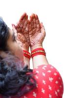 bella mujer vestida como tradición india con diseño de henna mehndi en ambas manos para celebrar el gran festival de karwa chauth con un fondo completamente blanco foto