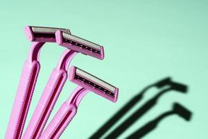 Disposable razors, a creative composition of disposable razors on a turquoise background photo