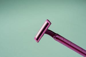 Disposable razor, a creative composition of a disposable razor on a turquoise background photo