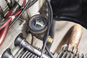 Oil pressure gauge of the opposed carburetor engine of an old motorcycle, an old motorcycle motor close-up photo
