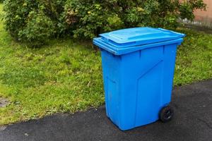 contenedor de basura azul de plástico en el patio de un edificio residencial foto