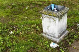 un contenedor de basura con desechos y un respirador usado descartado, máscara de respirador, usado para proteger contra la epidemia foto