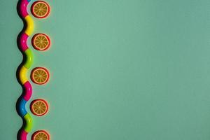 Creative composition on a turquoise background of orange slices and a wavy snake, waves, a minimalistic concept photo