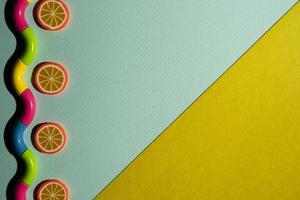 Creative composition on a turquoise-yellow background of orange slices and a wavy snake, waves, a minimalistic concept photo