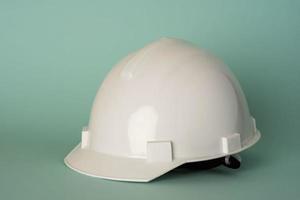 casco protector de construcción blanco sobre fondo turquesa, seguridad, protección laboral foto