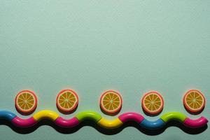 Creative composition on a turquoise background of orange slices and a wavy snake, waves, a minimalistic concept photo