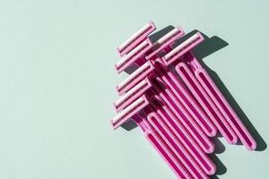 Disposable razors, a creative composition of disposable razors on a turquoise background