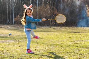 Little girl having fun on Easter. Kids in bunny ears. Toddler kid playing outdoor. photo