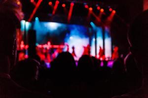 toma de algunos fanáticos que animan durante un concierto en vivo, ruido visible debido a iso alto, enfoque suave, dof poco profundo, ligero desenfoque de movimiento foto