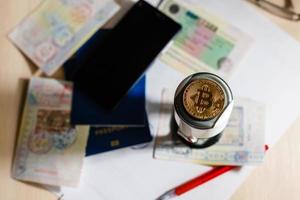 pasaportes extranjeros y monedas de bitcoin ucranianas y dólares de concepto de criptomoneda foto