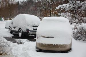 nieve en los coches después de las nevadas escena urbana de invierno foto