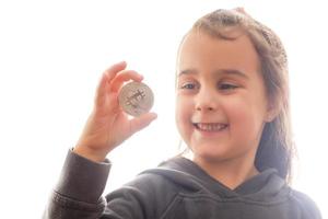 Golden bitcoin in a child hand digitall symbol of a new virtual currency selective focus photo