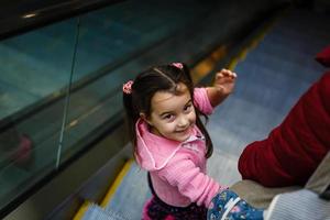 mother and child together on escalator background. Shopping mall, airport travel, love care photo