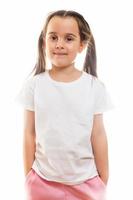 Positive little girl in casual white t shirt indicates at blank space for logo design photo