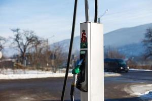 Fuel Dispenser with gas nozzle in gasoline station on winter season photo