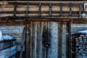 fondo de textura de madera oscura. antigua puerta de madera en invierno foto