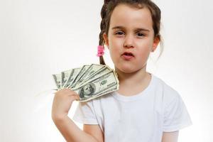 Cute little girl with money on white background photo