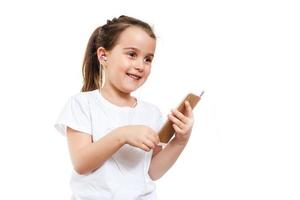 Beautiful little girl using smart phone listen music photo