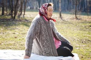 Alone old woman sitting in the park photo