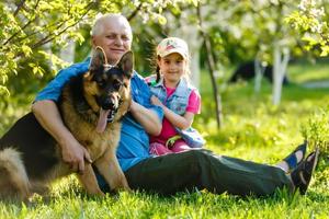 Grandfather with granddaughter dog and a dog in the garden photo