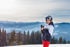 Panoramic shot of a female skier resting on top of the mountain observing nature at ski resort on a beautiful sunny winter day copyspace peaceful recreational vacation travel concept photo
