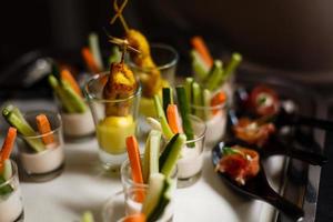 Verrines aperitivo con paté de salmón caviar rojo pepino queso crema hierbas alcaparras en vasos foto