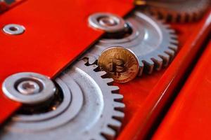 Gears and cogs close up and bitcoin coin photo