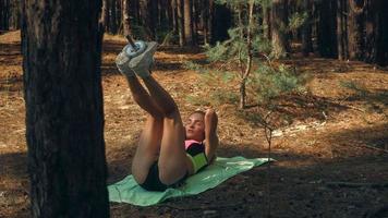 young slender  girl lies on her back and shakes press in the forest video