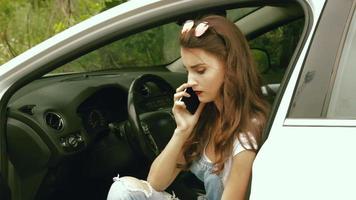 young gorgeous girl sitting in a white car and talking on the phone video