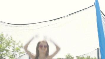 jeune fille mince en maillot de bain saute sur le trampoline video