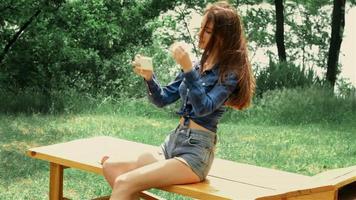 young  girl in denim shorts and shirt sits on the bench and straightens hair video