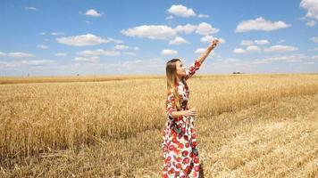 happy young girl standing in a field looking up at the sky and lets blow bubbles video