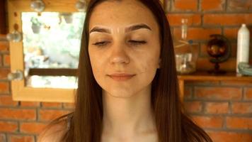 uma jovem olha para uma pessoa e determina o formato de suas sobrancelhas com um lápis video